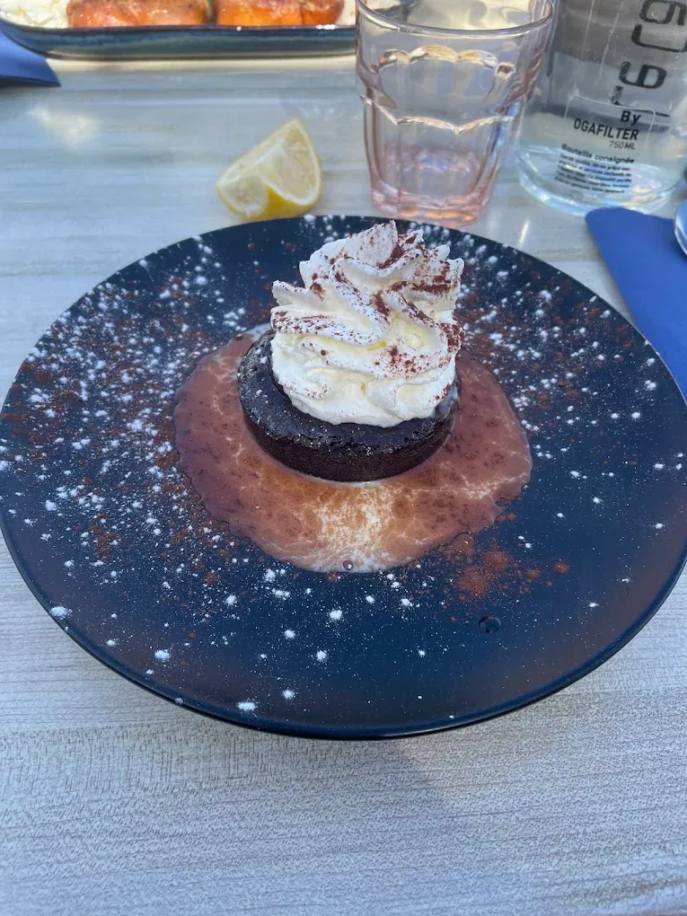 Dessert au chocolat et chantilly sur une assiette bleu nuit